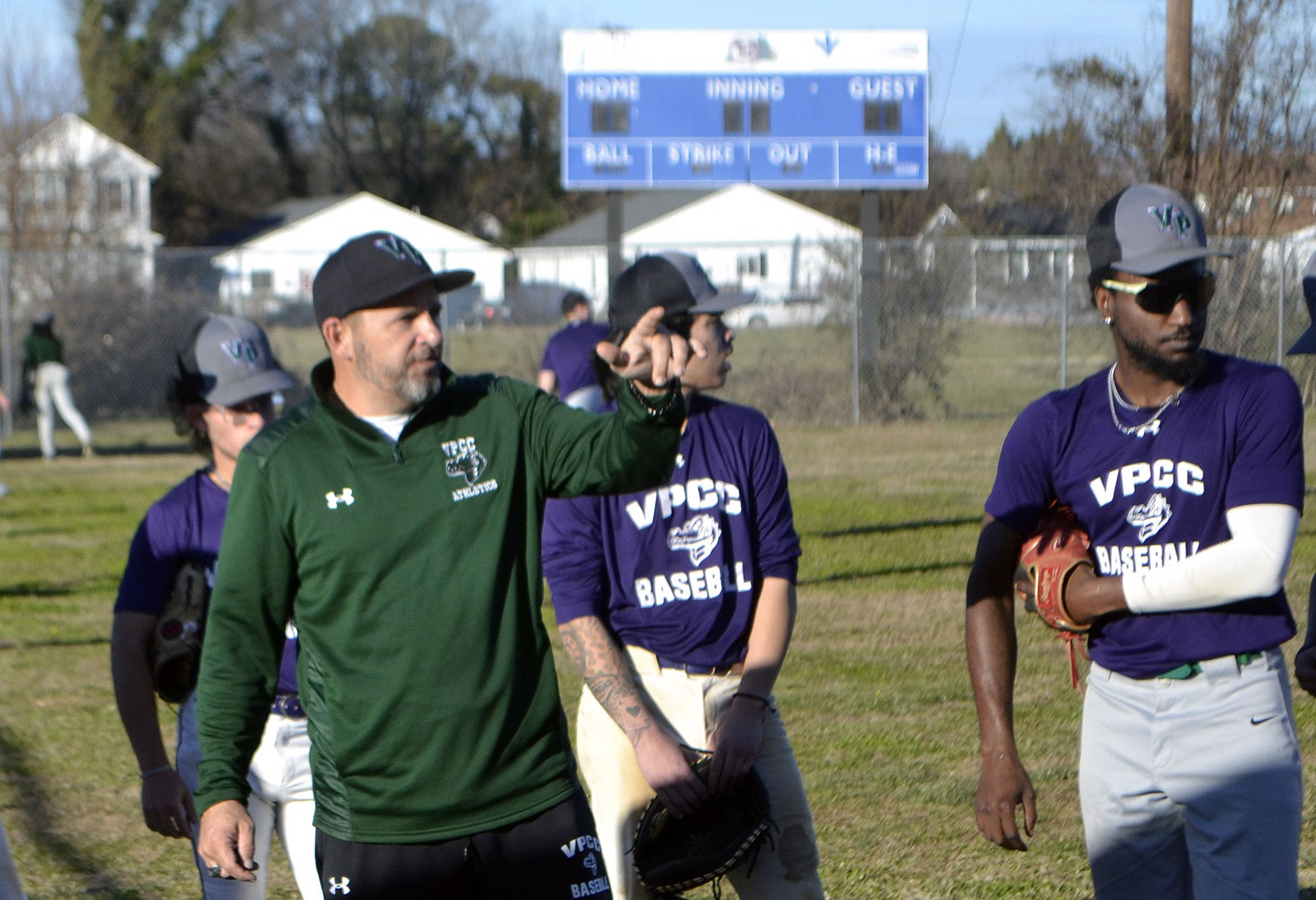 Baseball coach Shane Harrison gives pointers during a practice